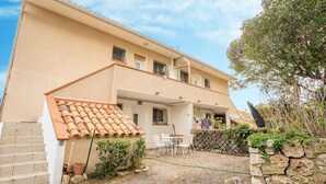 A two-story building with a tiled roof, a stone wall, and a gravel courtyard with outdoor furniture. - Cosy apartment for 4 guests with WIFI, TV and patio (Fréjus)