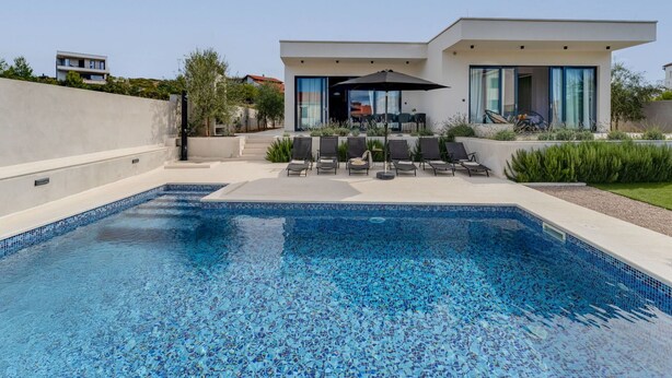 A modern pool area with a clear blue mosaic pool, sun loungers, and a patio with a table and chairs. - Wonderful private villa for 8 guests with WIFI, private pool, A/C, TV and terrace (Vodice)