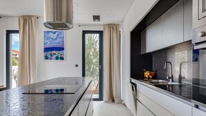 A modern kitchen with a large island, stainless steel appliances, and a view of the outdoors. - Wonderful private villa for 8 guests with WIFI, private pool, A/C, TV and terrace (Vodice)
