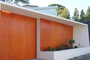 A modern building with a flat roof, white exterior walls, and a wooden panel accent.