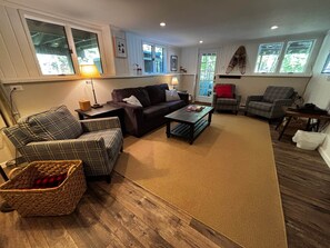 A living room with a sofa, armchairs, a coffee table, and a fireplace.
