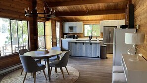 A modern kitchen with white cabinets, stainless steel appliances, and a central island.