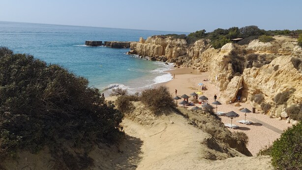 A coastal beach with rocky cliffs, a sandy path, and beach umbrellas. - Studio in Gale Albufeira (Albufeira)