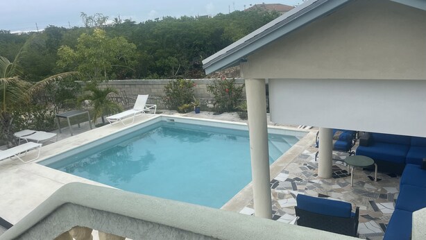 Una piscina con lettini e un'area relax all'ombra.