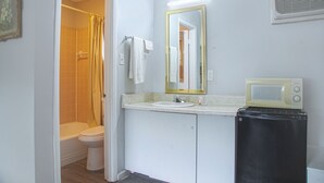 A bathroom with a toilet, sink, and a microwave on the countertop. - OYO Hotel Calhoun, GA I-75 (Calhoun)