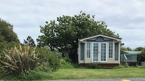 Une petite maison de plain-pied, dotée d’un toit à pignon et d’un porche à l’avant.