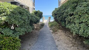 Un camino que lleva a una playa, con edificios a ambos lados.