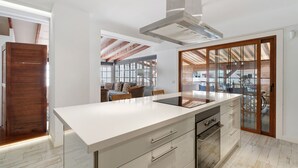 Una cocina moderna con una isla grande, horno empotrado y vistas al exterior.