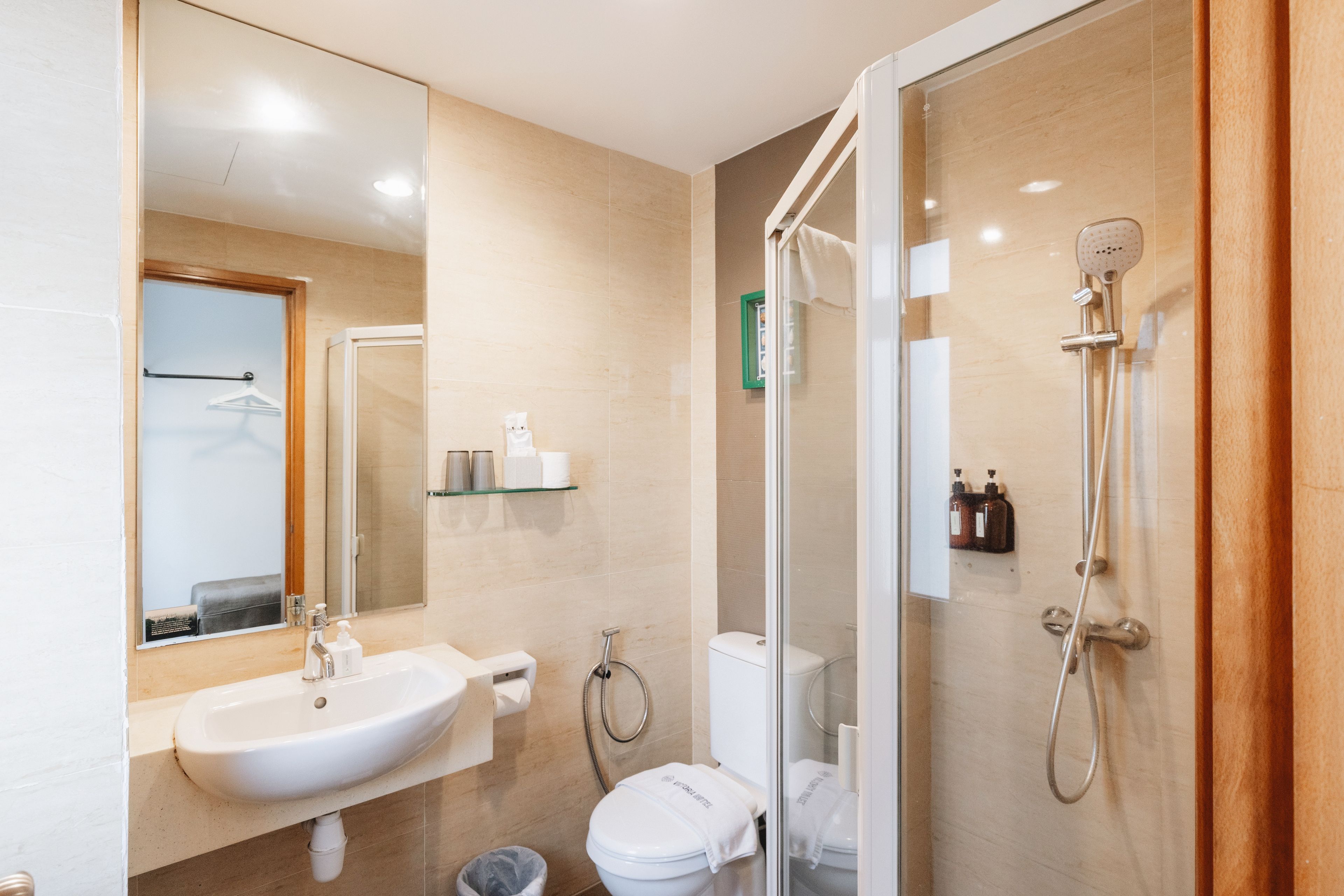 Un baño moderno con ducha de mampara de vidrio, un lavabo y un inodoro.