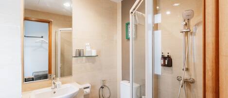 Un baño moderno con ducha de mampara de vidrio, un lavabo y un inodoro.