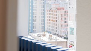 A view through an arched window of a cityscape with multiple buildings.
