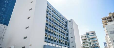 Un edificio moderno con facciata bianca e numerose finestre.