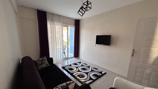 A modern living room with a sofa, a coffee table, and a patterned rug. - The Titanic House (Denizli)