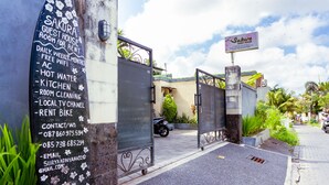 Une maison d’hôtes avec une pancarte indiquant les services offerts, tels que la location à la journée, à la semaine ou au mois, le Wi-Fi gratuit, la climatisation, l’eau chaude, une cuisine, le nettoyage des chambres, une chaîne de télévision locale et la possibilité de louer un vélo.