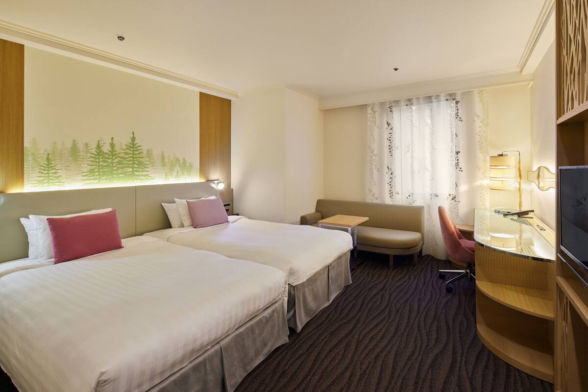 A hotel room with two beds, a sofa, a desk, a TV, and a window with a forest mural.