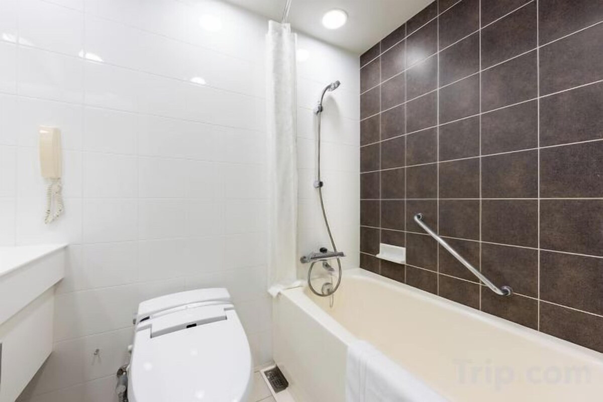 Badezimmer | Duschwanne, Haartrockner, Hausschuhe, Toilette mit elektrischem Bidet