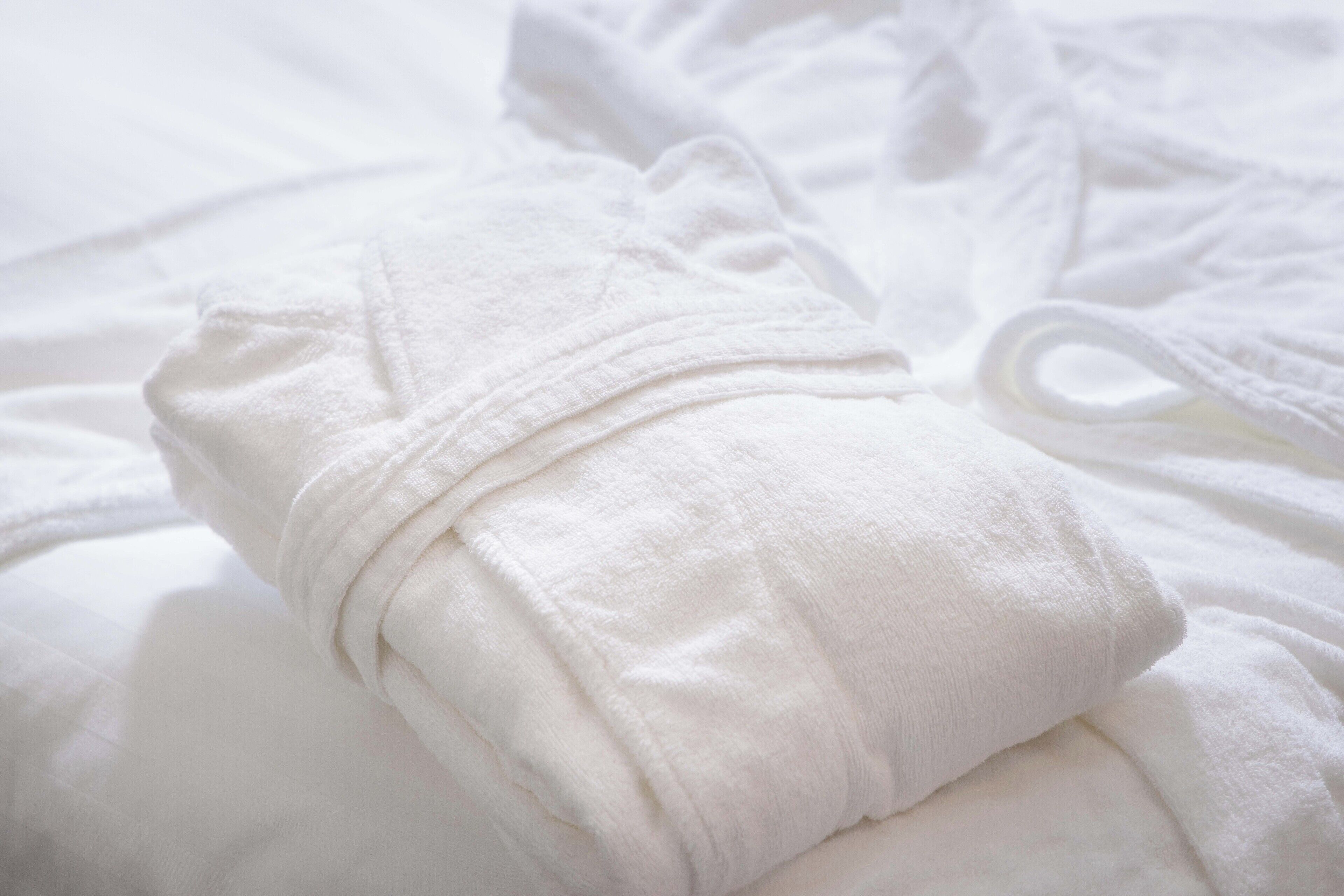 Una toalla blanca doblada cuidadosamente sobre una cama.