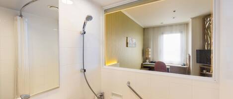 Een moderne badkamer met een bad, douche, wastafel en spiegel.