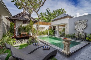 A private pool area with lounge chairs, a decorative stone fountain, and lush greenery. - Privet pool with 2bedroom villa in quite area. (Bali)
