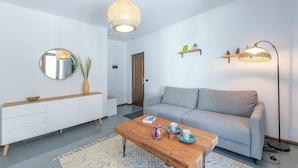 A modern living room with a sofa, coffee table, and decorative items. - The Rock View With Balcony and Parking (Arco)