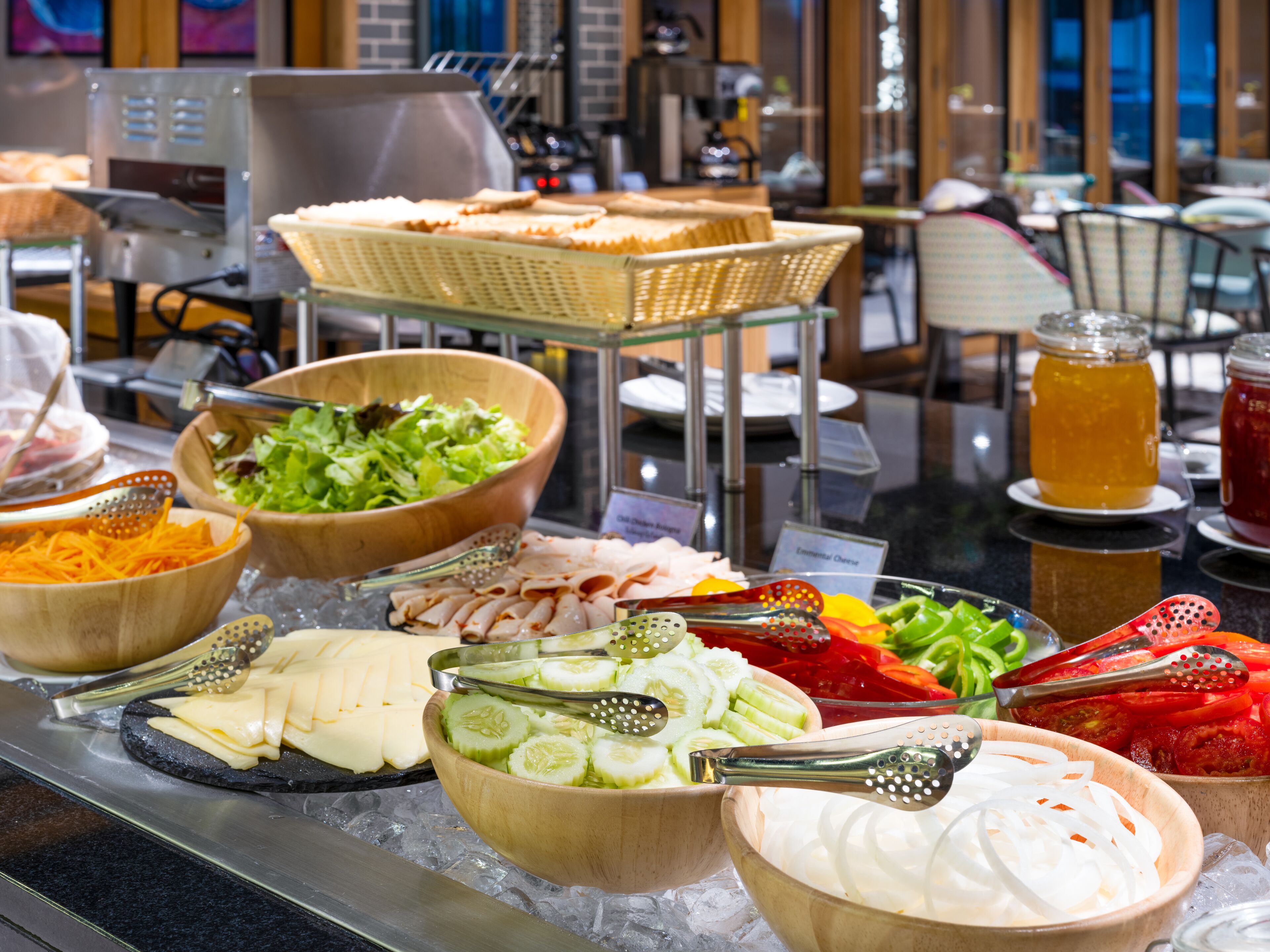 A buffet with various food items including cheese, vegetables, and meats.