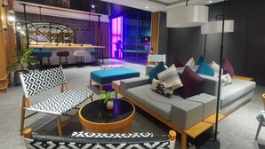 A modern living room with a sofa, chairs, and a coffee table. - GLOW Mira Karon Beach (Karon)