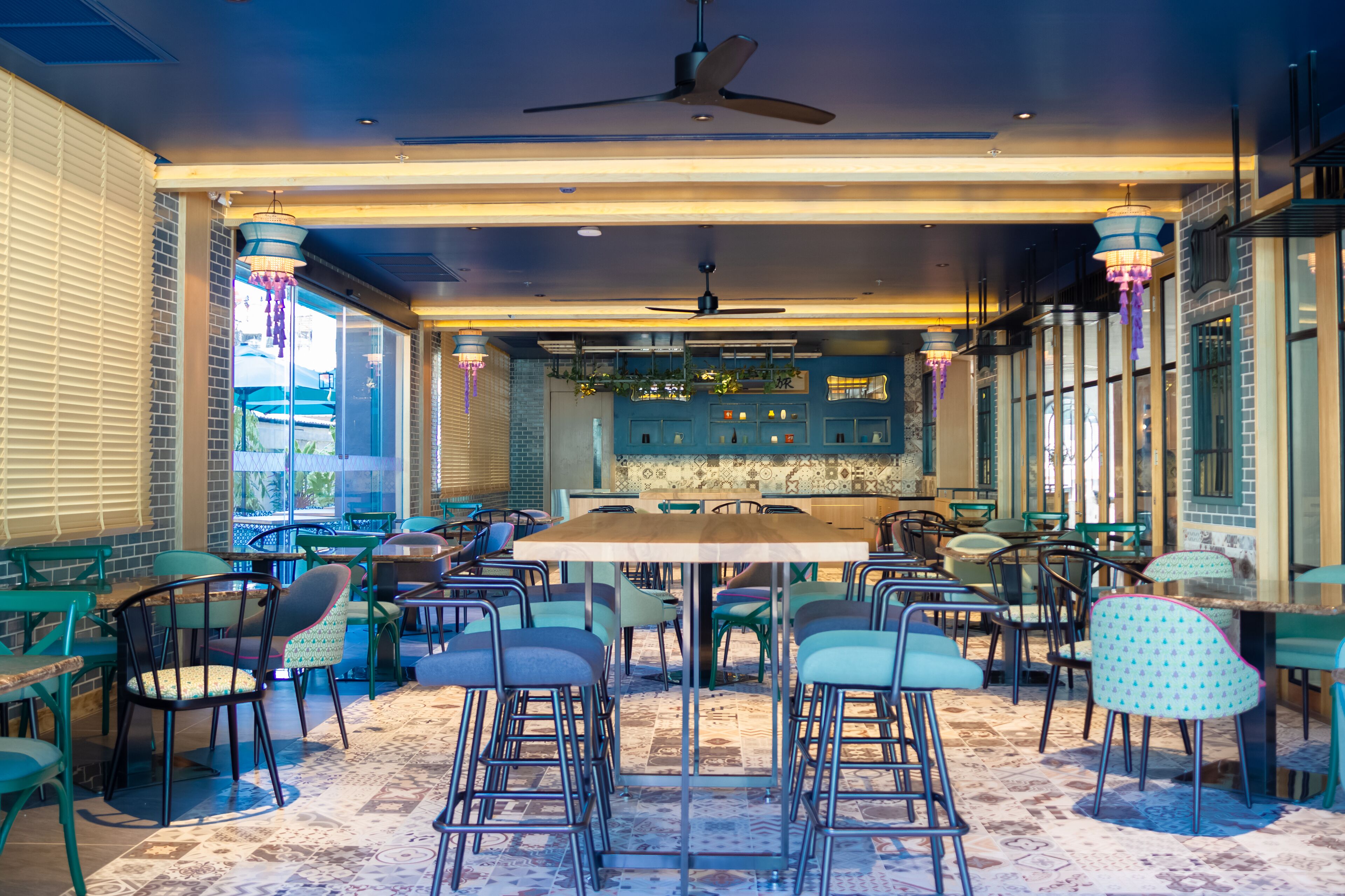 A restaurant with a central dining area, multiple seating options, and a bar area with shelves of bottles.