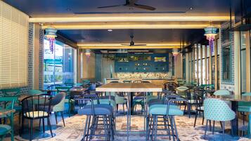 A restaurant with a central dining area, multiple seating options, and a bar area with shelves of bottles.