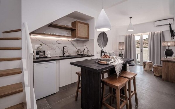 Una cocina moderna con una isla central, armarios blancos y un horno empotrado.
