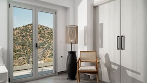 Een moderne kamer met een schuifdeur naar een balkon, een hoge staande lamp, een houten stoel en een kledingkast.