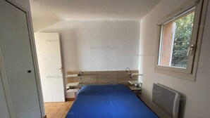 A bedroom with a bed, a window, and a radiator.