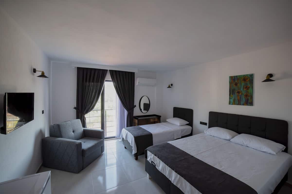 A modern hotel room with two beds, a sofa, a TV, and a painting.