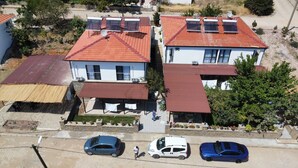 Zona residencial amb cases amb teulades vermelles i panells solars. Hi ha tres cotxes aparcats al primer terme.