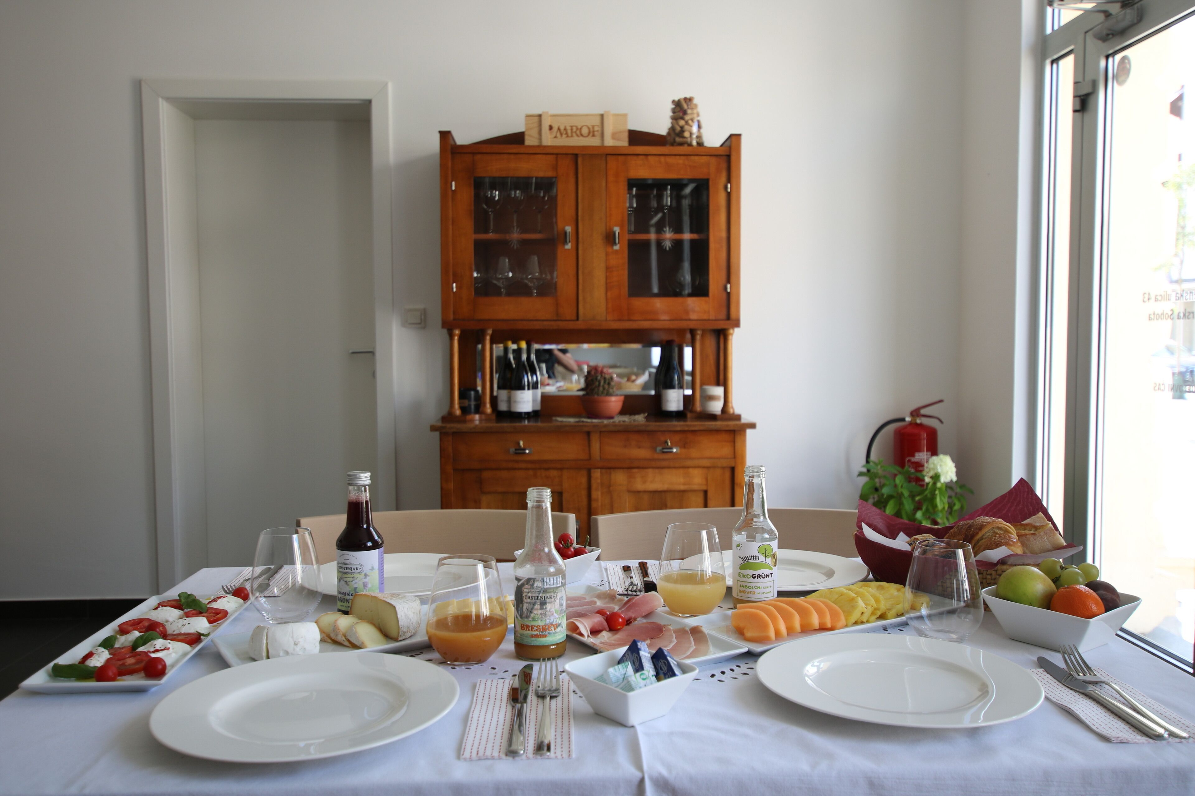 Una mesa de comedor servida con platos, cubiertos y una variedad de comida y bebidas.