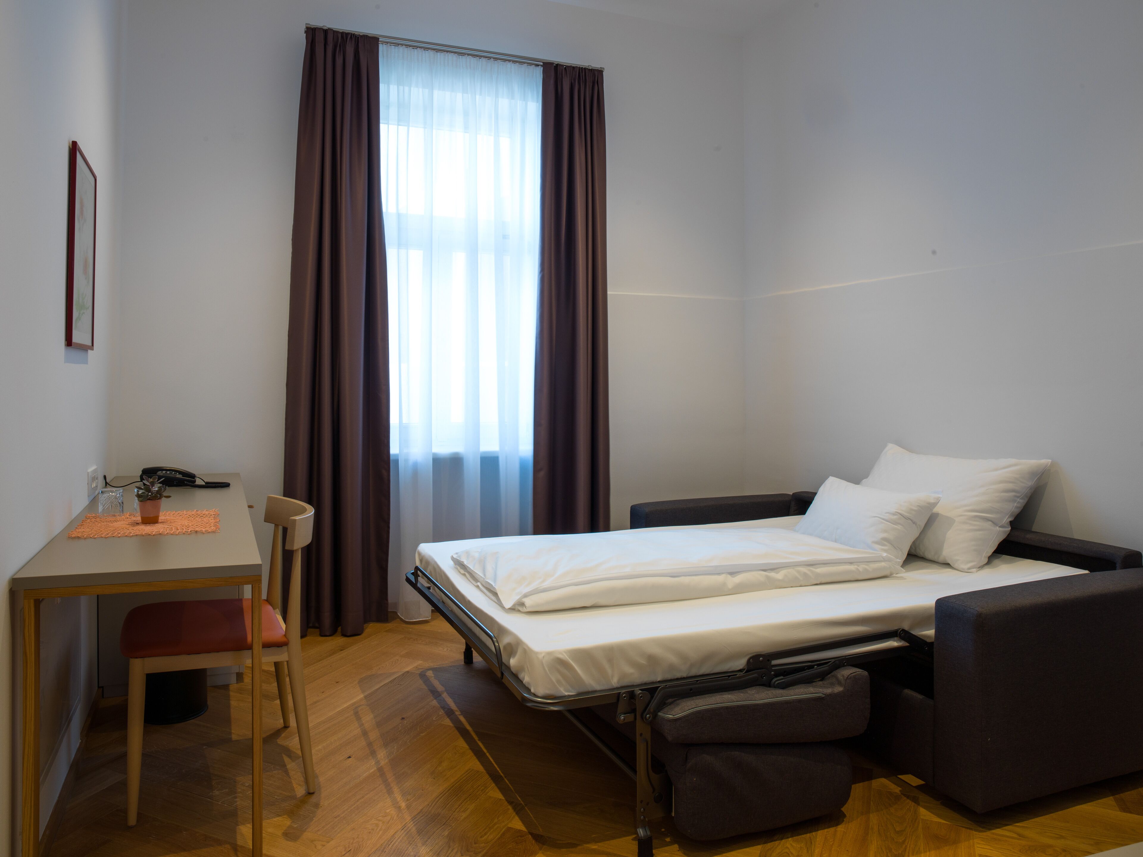 A compact room with a bed, a desk, and a chair.