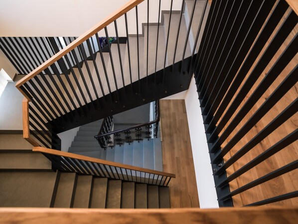 A modern staircase with wooden and metal railings, leading to a landing with a light fixture. - HOTEL BELMUR (Murska Sobota)