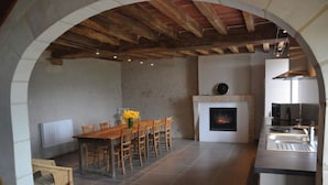 A spacious room with a dining area, a fireplace, and a kitchen. - Self catering accomodation CHEZ GERARD, CHAUMONT sur LOIRE, ideal for a family or group of friends (Chaumont sur loire)