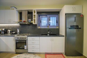 Departamento familiar, varias habitaciones, frente al mar (Maritinas Stone Apartment On The) | Cocina privada | Refrigerador, horno, parrilla de estufa y cafetera y tetera 