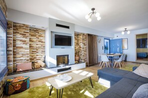 Casa familiare, camere multiple, fronte mare (Maritinas Stone House On The Beach) | Area soggiorno | TV 21 pollici con canali via cavo, caminetto