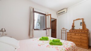 A bedroom with a bed, a dresser, a mirror, and a window with curtains. - Villa Luna with private pool near the beach for 6 persons, AC, WiFi (Alcudia)