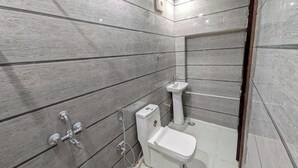 Un baño con inodoro, lavamanos y ducha.