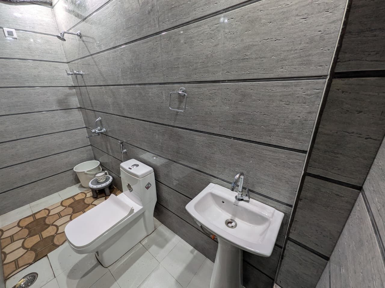 A bathroom with a toilet, bidet, and sink, all with modern fixtures.