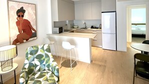 A modern apartment with a kitchen, dining area, and living room. - Apartamentos 525 Los Narejos (Los Alcazares)