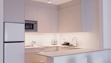 A modern kitchen with a built-in microwave, a sink, and a refrigerator.