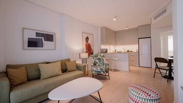 Una sala de estar moderna con un sofá, una mesa de centro y un reposapiés estampado.