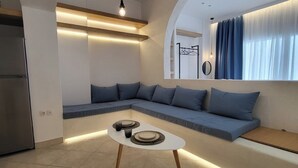 Uma sala de estar moderna com um sofá seccional, uma mesa de centro e uma área de cozinha.