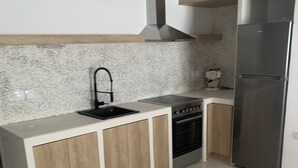 Uma cozinha com pia, fogão e geladeira.