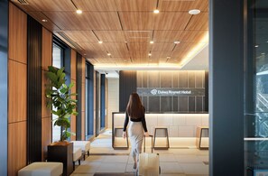 A modern hotel lobby with a reception desk, seating area, and a large potted plant. - Daiwa Roynet Hotel Kumamoto (Kumamoto)