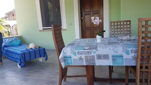 A room with a bed, a table with chairs, and a door.