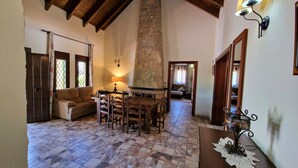 A cozy living room with a stone fireplace, wooden furniture, and a tiled floor. - Quiet Villa with heated swimming pool, barbecue and views. (Alhaurín el Grande)